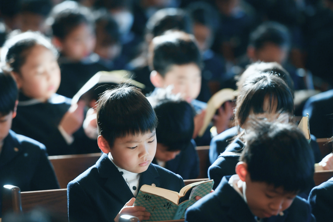 礼拝で聖書を読む生徒たち